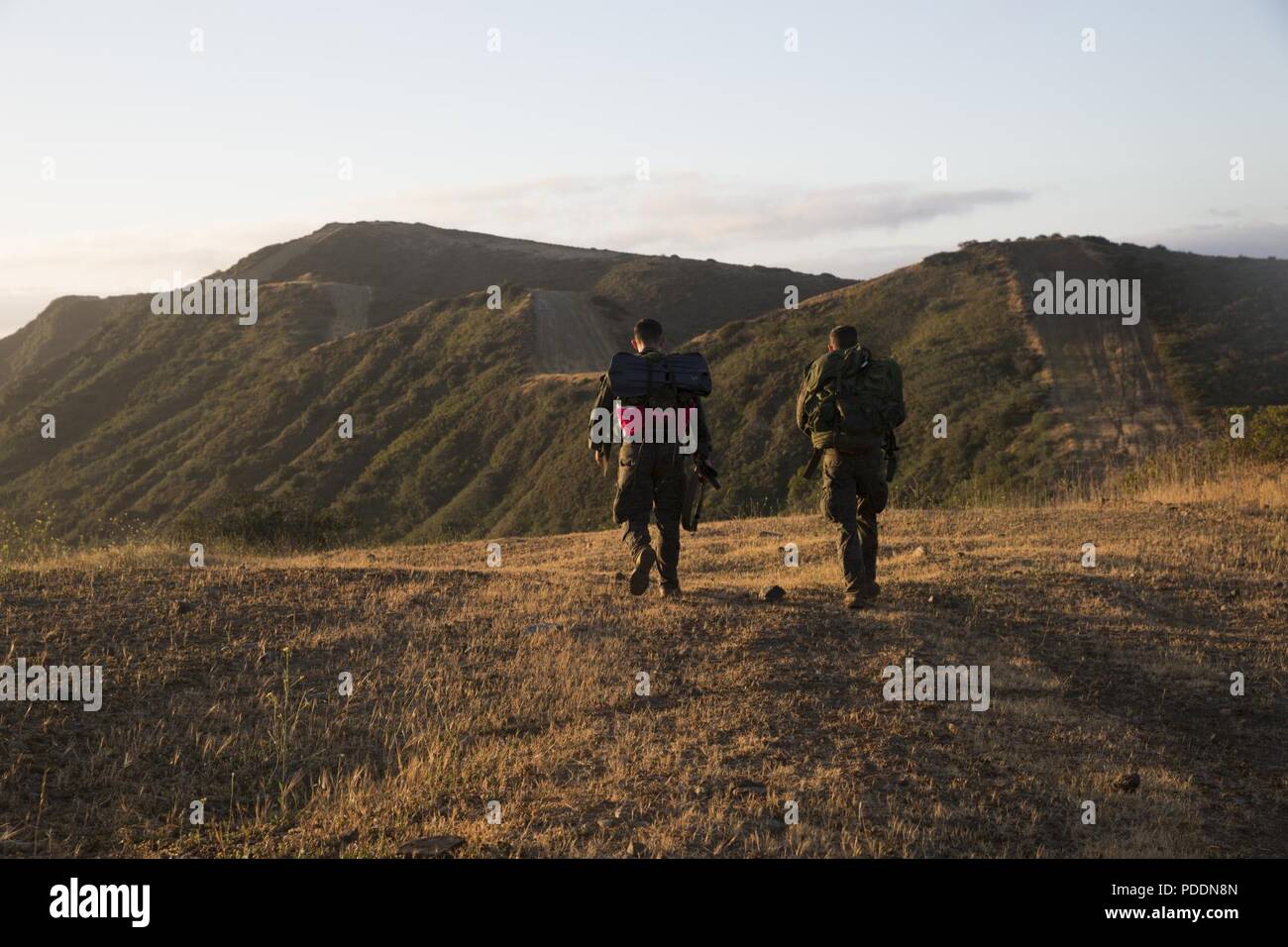 Sergeants Timothy A. Perez, team leader, 3rd radio reconnaissance platoon, Marine Corps Base Hawaii, and John A. Colaluca, team leader, force reconnaissance platoon, 31st Marine Expeditionary Unit, travel towards the next station during the 10th Annual Recon Challenge at the 52 Area, Marine Corps Base Camp Pendleton, Calif., May 17, 2018. The participants hiked 25 miles with checkpoints where corpsmen assessed the Marines’ physical and mental well-being, while carrying a memorial flag to honor fallen recon Marines. Stock Photo