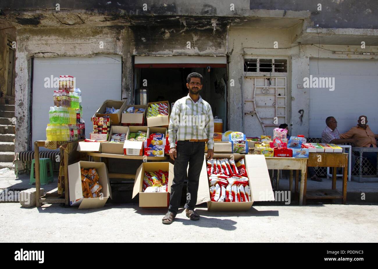 A shop owner poses in front of his stand in Old Mosul, May 14, 2018.  Although ISIS insurgents devastated Old Mosul during the battle to reclaim the city, residents have persevered thanks to aid from the government of Iraq, humanitarian organizations, and a secure and stable environment provided by Iraqi and Coalition forces. Stock Photo