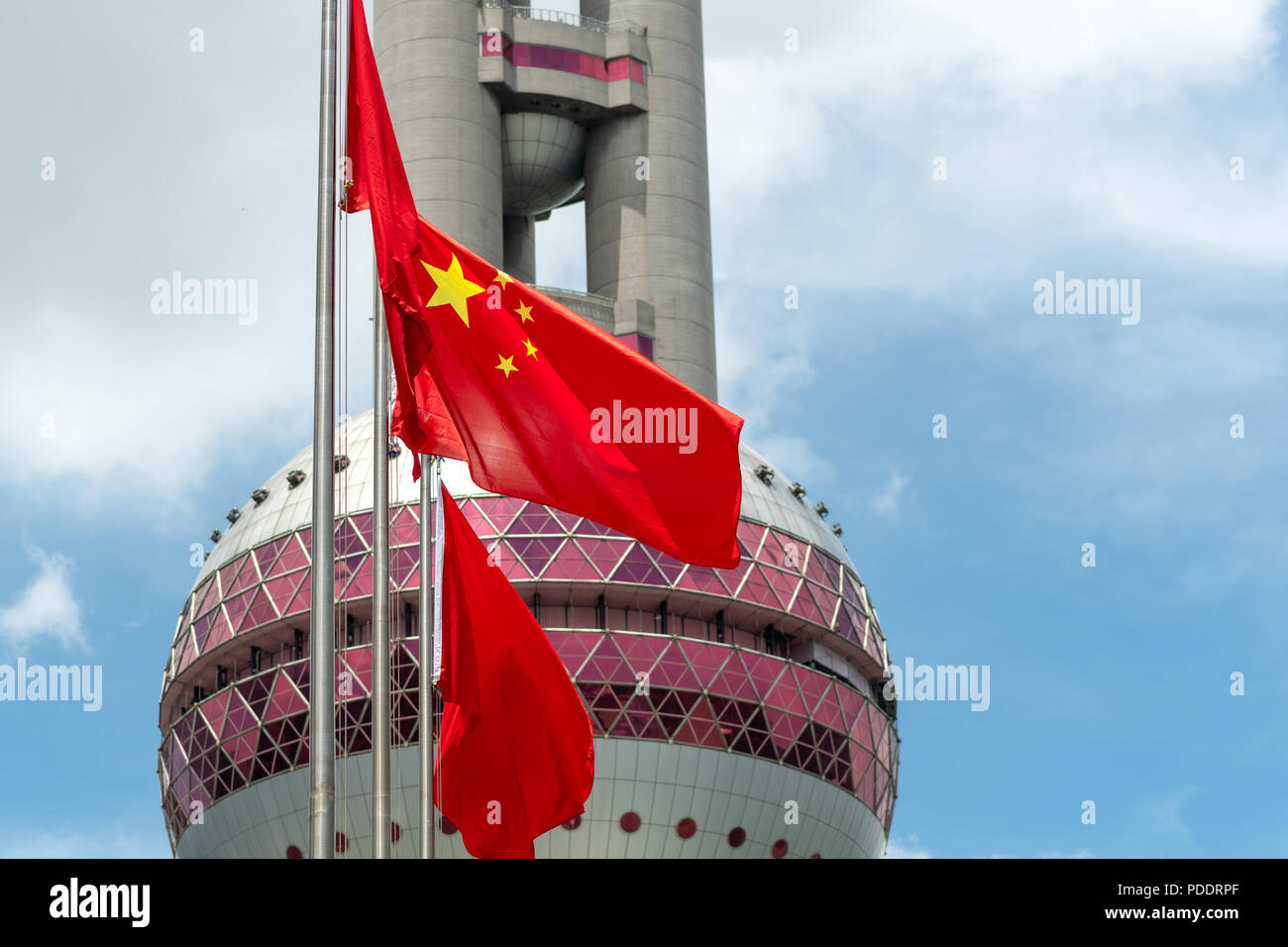 Chinese landmark (Oriental Pearl Television tower) and China national flag in Pudong district of Shanghai Stock Photo