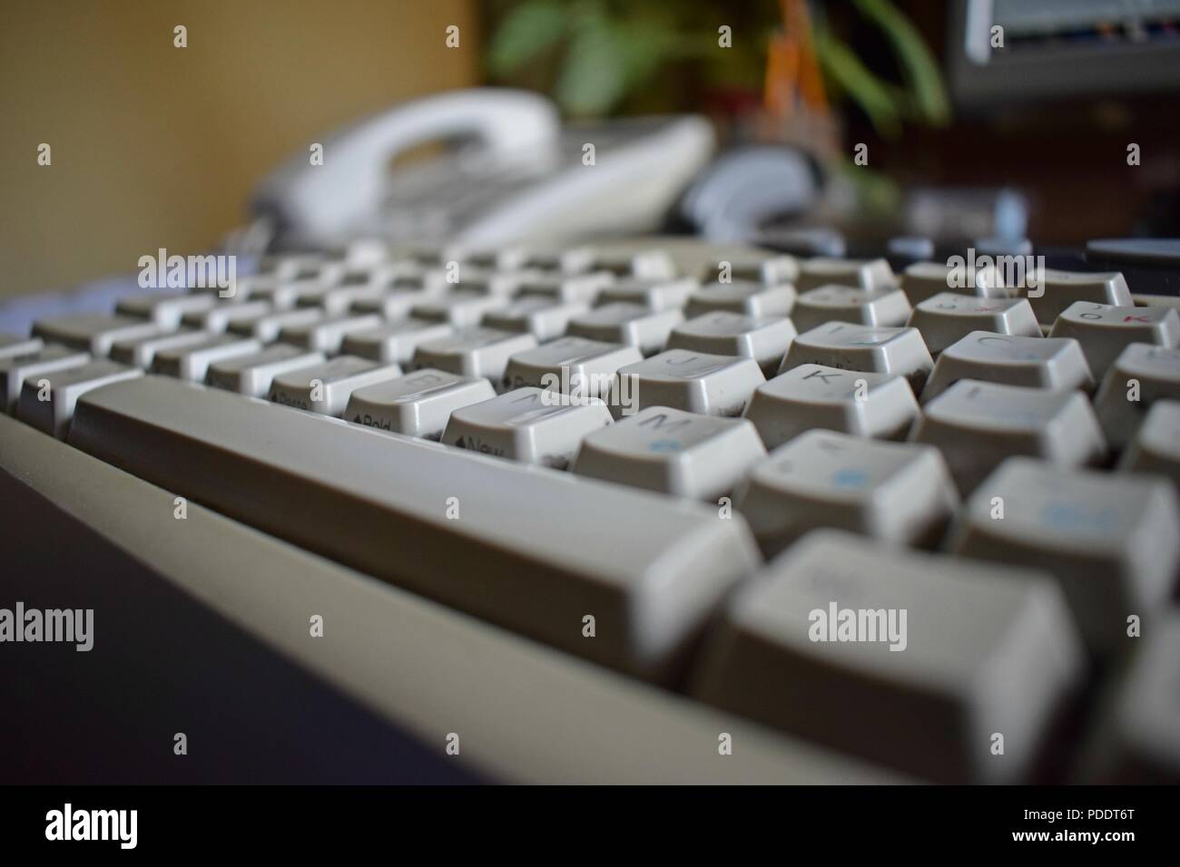 Closeup image of a keyboard and office space. Office time. Computer equipment. Workplace of an office employee. Stock Photo