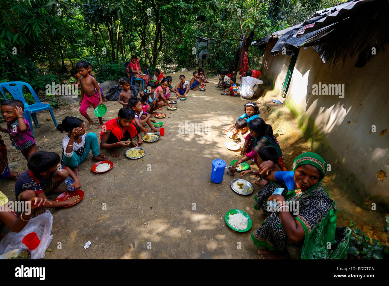 Hindu refugees are given meals at a temporary shelter near Kutupalong in Cox's Bazar. Hundreds of Hindus fled Myanmar's Rakhine to seek shelter in Cox Stock Photo