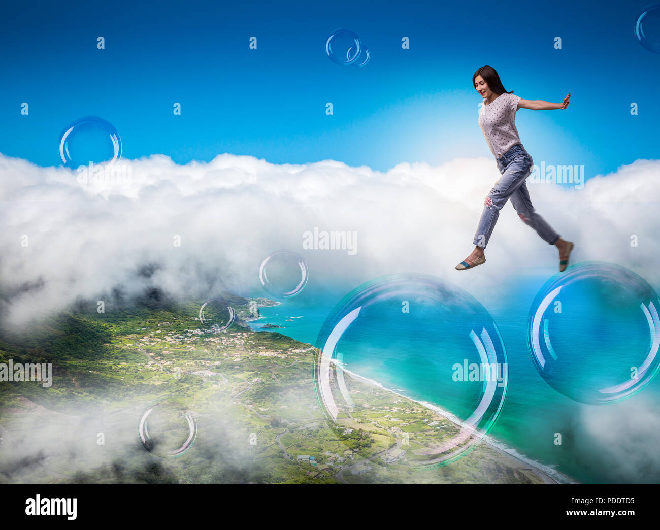 Cute woman jumping in the sky on big soap bubbles Stock Photo