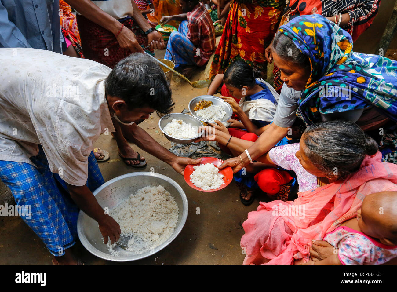 Hindu refugees are given meals at a temporary shelter near Kutupalong in Cox's Bazar. Hundreds of Hindus fled Myanmar's Rakhine to seek shelter in Cox Stock Photo