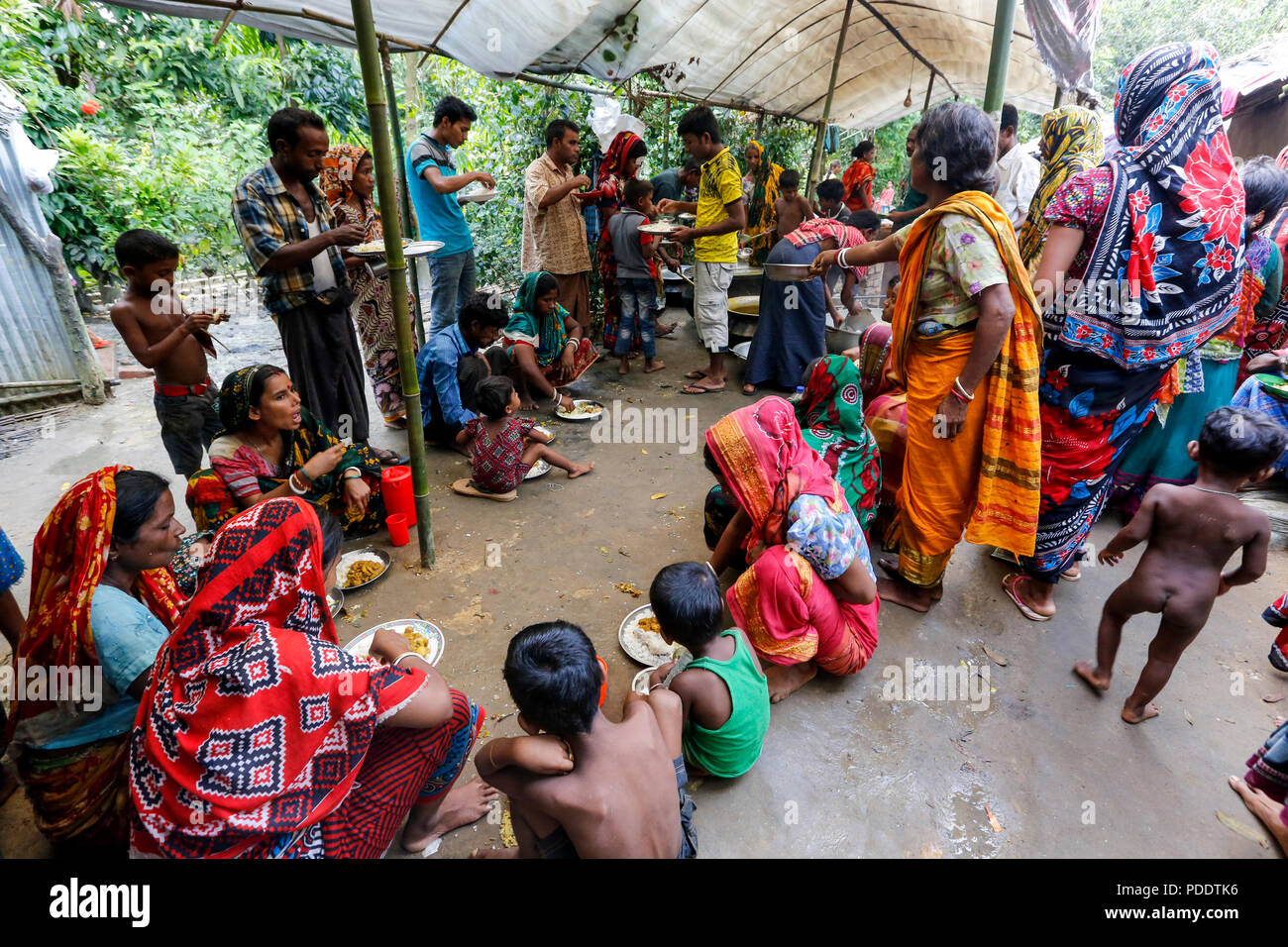 Hindu refugees are given meals at a temporary shelter near Kutupalong in Cox's Bazar. Hundreds of Hindus fled Myanmar's Rakhine to seek shelter in Cox Stock Photo