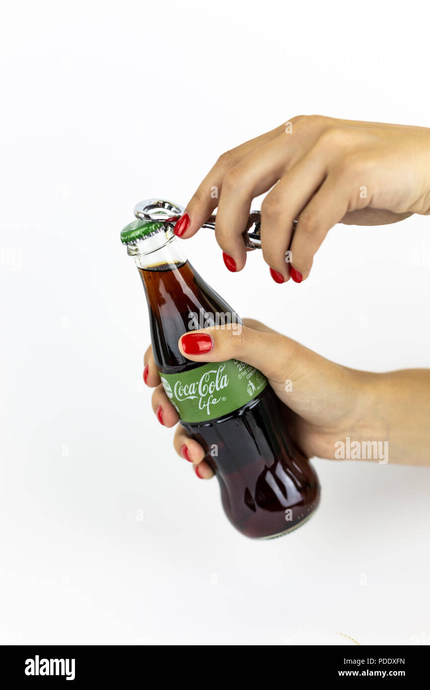 Atlanta, Georgia, USA - July 22, 2018: woman hand with red nails holding Coca-Cola Life Green glass coca-cola contour classic bottle from UK on white background Stock Photo