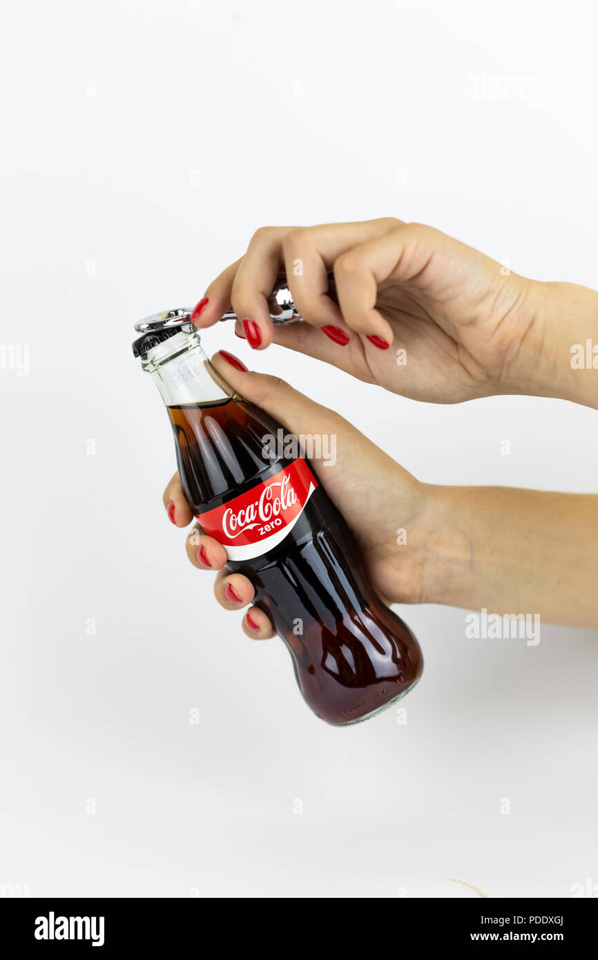 Atlanta, Georgia, USA - July 22, 2018: woman hand with red nails holding vintage glass coca-cola zero contour classic bottle from Russia on white background Stock Photo