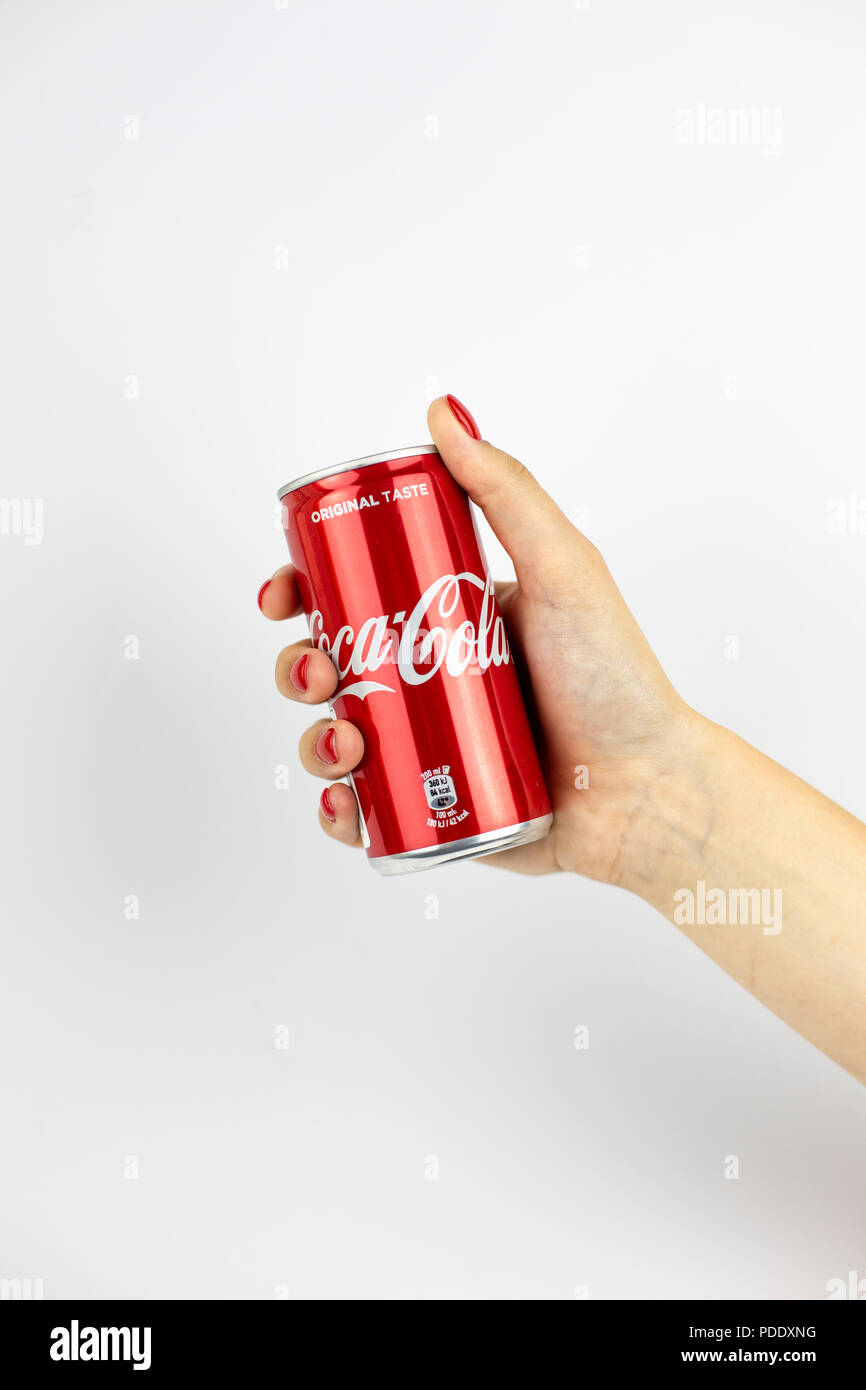 Atlanta, Georgia, USA - July 22, 2018: woman hand with red nails holding tiny aluminum can coca-cola classic from USA isolated on white background Stock Photo