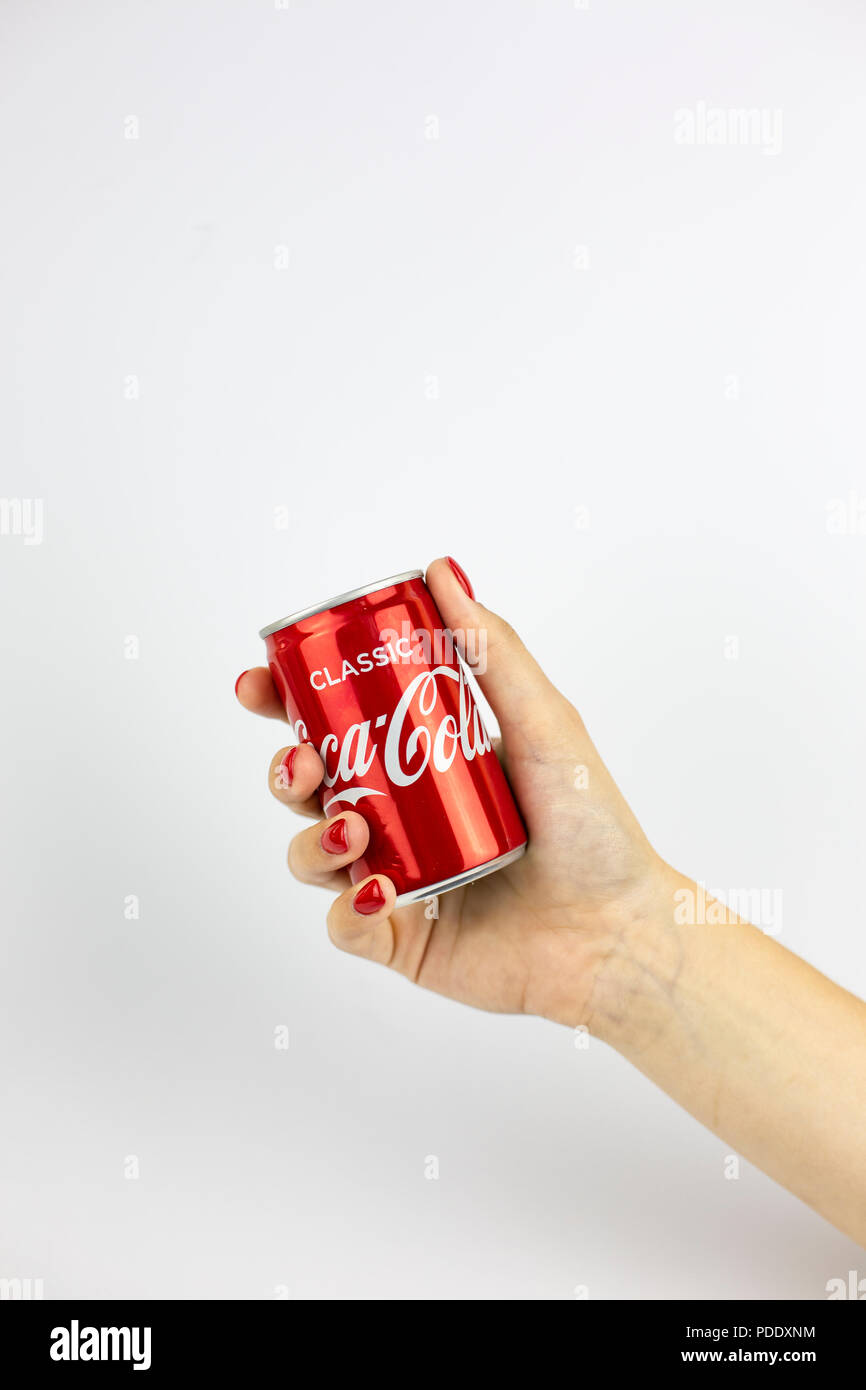 Atlanta, Georgia, USA - July 22, 2018: woman hand with red nails holding tiny aluminum can coca-cola classic from UK on white background Stock Photo