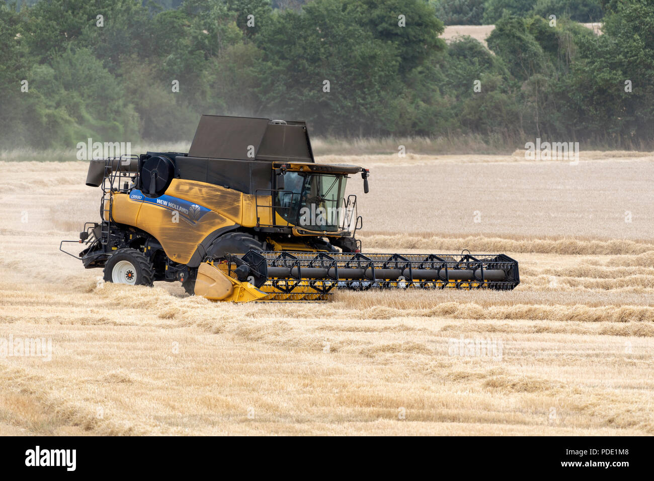 Combine harvester at work on farmland at harvest time in Hampshire