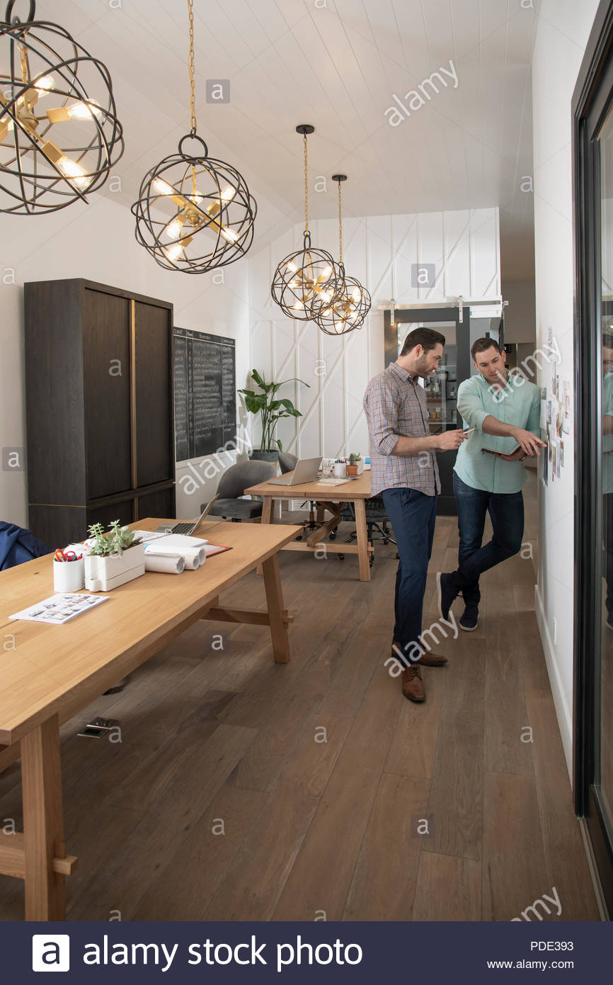 Home builder architect and designer planning at wall in office Stock