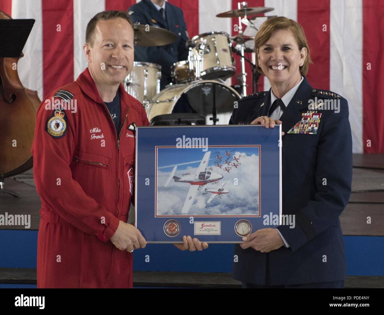 Lt. Col. Mike French (left), commander of the Royal Canadian Air Force’s Snowbirds, presents Gen. Lori J. Robinson, commander of North American Aerospace Defense Command and U.S. Northern Command, with a lithograph at the NORAD 60th Anniversary Ceremony on Peterson Air Force Base Colorado, May 12, 2018. The ceremony and static display of various NORAD aircraft was the culmination of a three-day event, which included a media tour of Cheyenne Mountain Air Force Station, the dedication of a cairn outside the commands' headquarters building memorializing the Canadians who have passed away while se Stock Photo