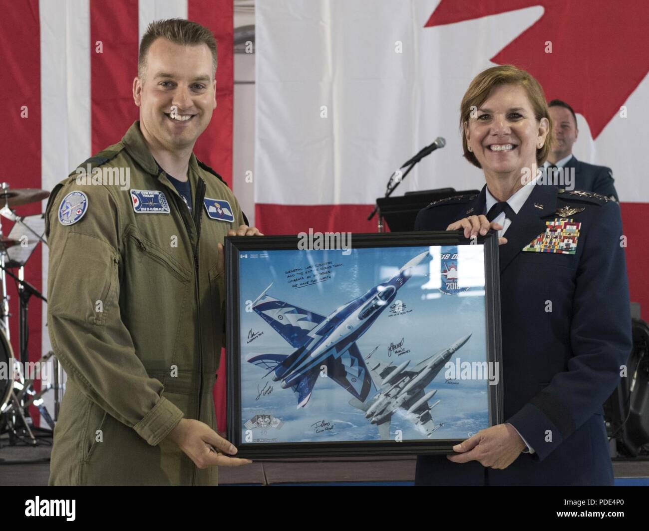 Royal Canadian Air Force Capt. Stephan Porteus presents Gen. Lori J. Robinson, commander of North American Aerospace Defense Command and U.S. Northern Command, with a lithograph at the NORAD 60th Anniversary Ceremony on Peterson Air Force Base Colorado, May 12, 2018. The ceremony and static display of various NORAD aircraft was the culmination of a three-day event, which included a media tour of Cheyenne Mountain Air Force Station, the dedication of a cairn outside the commands' headquarters building memorializing the Canadians who have passed away while serving NORAD, and a fly over in missin Stock Photo