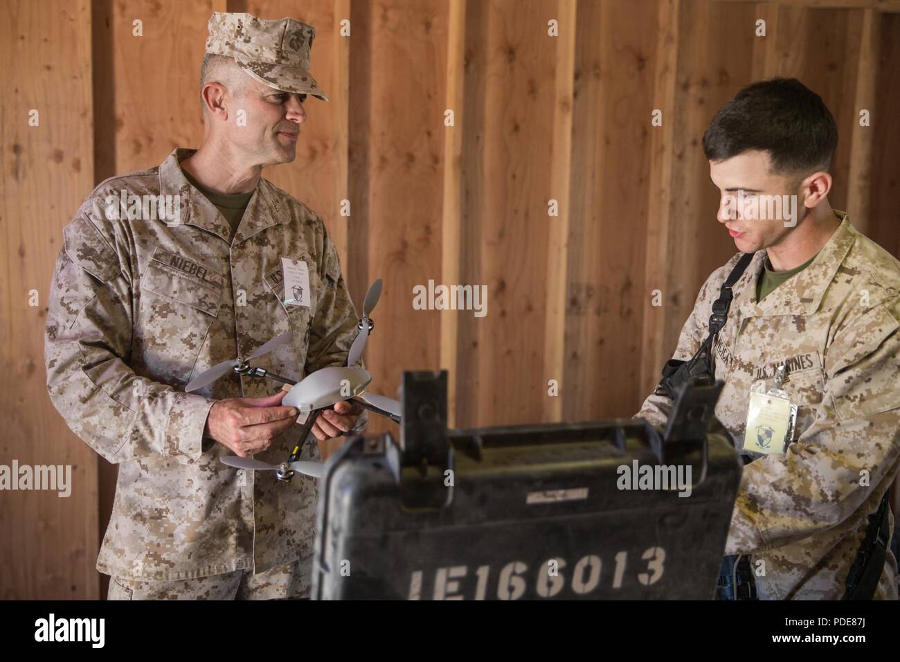 U.S. Marine Corps 2nd Lt. Michael Francica, right, with Combat Logistics Battalion 8, Combat Logistics Regiment 2, 2nd Marine Logistics Group, shows Col. Andrew Niebel, chief of staff, 2nd MLG, the InstantEye small unmanned aerial vehicle during Integrated Training Exercise 3-18 on Marine Corps Air Ground Combat Center, Twentynine Palms, Calif., May 14, 2018. The Chief of Staff visited ITX 3-18 to oversee the implementation of innovative technologies in a field environment. Stock Photo