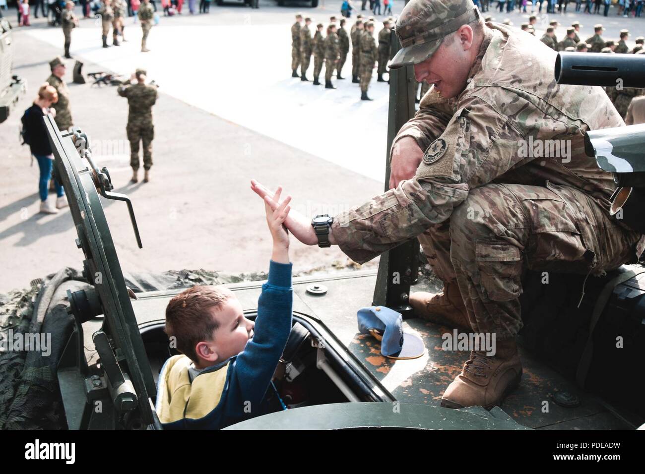U.S. Army Pfc. Tanner Shelko, an infantryman with 1st Squadron, 2nd Cavalry Regiment,high-fives a Polish citizen during an event to celebrate the anniversary of the polish boarder guard with Battle Group Poland at Ketrzyn, Poland, May 18, 2018. Battle Group Poland is a unique, multinational coalition of U.S., U.K., Croatian and Romanian Soldiers who serve with the Polish 15th Mechanized Brigade as a deterrence force in support of NATO’s Enhanced Forward Presence. Stock Photo