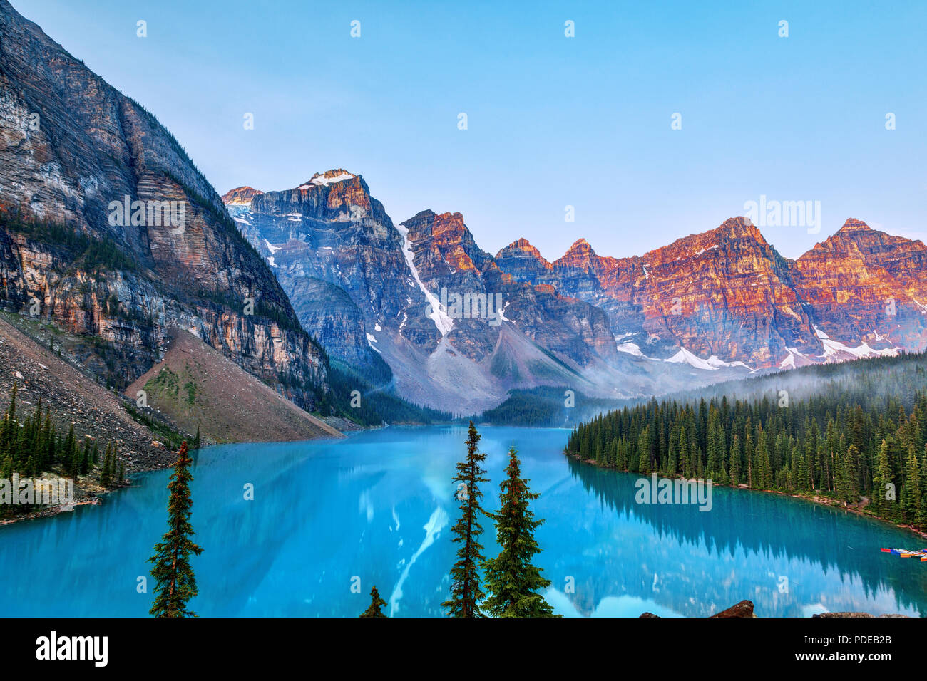 Sunrise over the Valley of the Ten Peaks with glacier-fed turquoise colored Moraine Lake in the foreground near Lake Louise in the Canadian Rockies. Stock Photo