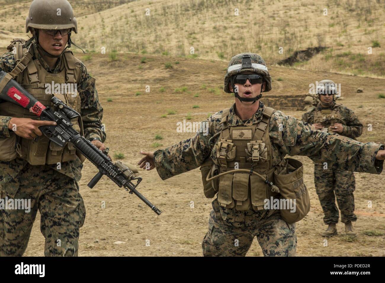 U.S. Marine Corps Sgt. Kathrine E. Cleary, right, combat instructor, School of Infantry (SOI)-West, directs students attending Marine Combat Training (MCT) off of a rifle range at the Marine Corps SOI-West, Camp Pendleton, Calif., May 18, 2018. MCT gives Marines with Military Occupational Specialties other than Infantry (03xx) a basic understanding of the Marine Corps' warfighting ethos, core values, basic tenets of maneuver warfare, leadership responsibilities, mental, moral, and physical resiliency in order to contribute to the successful accomplishment of their unit's mission. Stock Photo