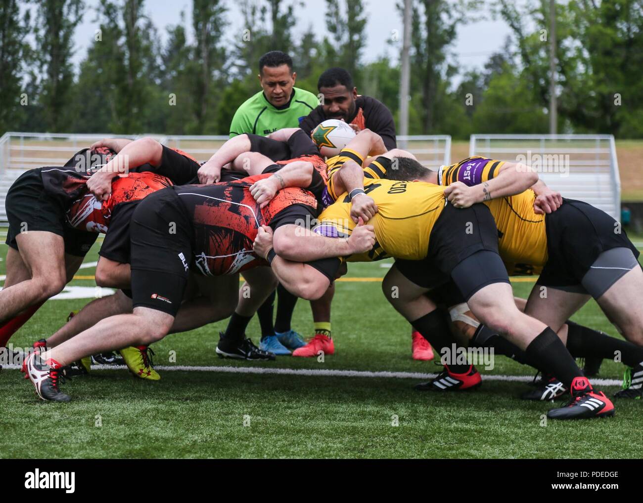 Soldiers from the Joint Base Lewis-McChord Army rugby team and seamen from the Bremerton Navy rugby team, collide with one another as they scrimmage to fight for the ball in the 20th