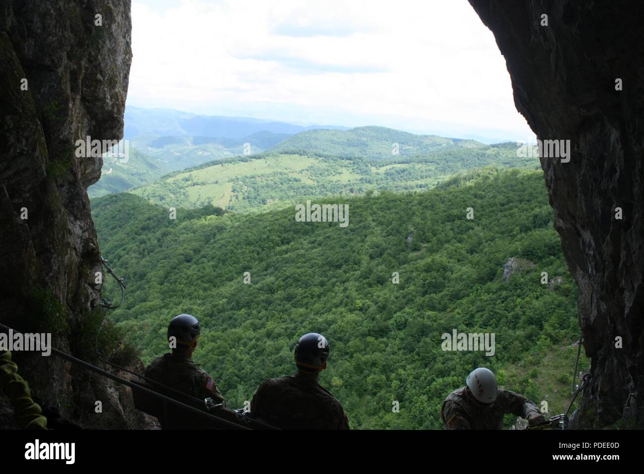 Lt. Col. Donald T. Braman, commander of the 3-61 CAV (left), 1st Chad R. Libby (middle), and Sgt. 1st Class Cecil E. Sherwood soak in the view inside a cave on Via Ferrata Berim in Kosovo on May 19. Stock Photo