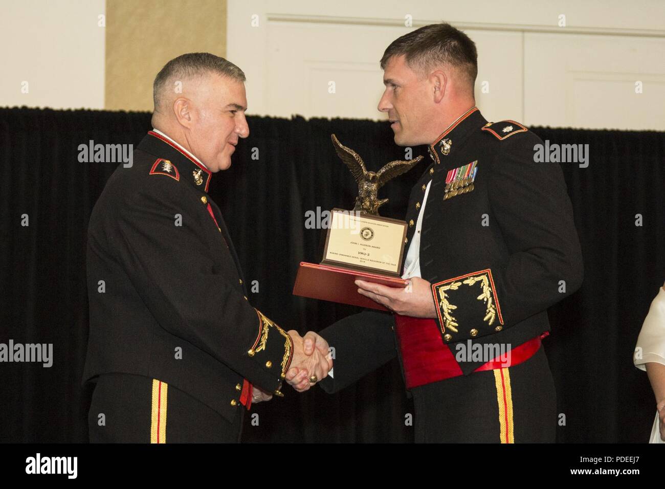 The Assistant Commandant of the Marine Corps Gen. Glenn M. Walters, left, presents the John I. Hudson Award for Marine Unmanned Aerial Vehicle Squadron of the Year to a representative from Marine Unmanned Aerial Vehicle Squadron 3 (VMU-3), Marine Aircraft Group 24 (MAG-24) during the 47th annual Marine Corps Aviation Association (MCAA) Symposium and Awards Banquet, San Diego, Calif., May 18, 2018. Walters was the guest speaker for the event and presented 13 unit awards and 16 individual awards during the ceremony. Stock Photo