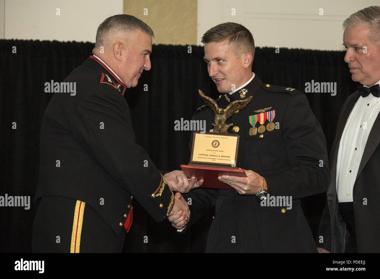 The Assistant Commandant of the Marine Corps Gen. Glenn M. Walters, left, presents the James Maguire Award for exceptional achievement in Marine Aviation to Capt. Joshua P. Brooks, ACT officer in charge, Department of Operational Safety and Standardization (DOSS), Marine Unmanned Aerial Vehicle Squadron 3 (VMU-3), Marine Aircraft Group 24 (MAG-24), during the 47th annual Marine Corps Aviation Association (MCAA) Symposium and Awards Banquet, San Diego, Calif., May 18, 2018. Walters was the guest speaker for the event and presented 13 unit awards and 16 individual awards during the ceremony. Stock Photo