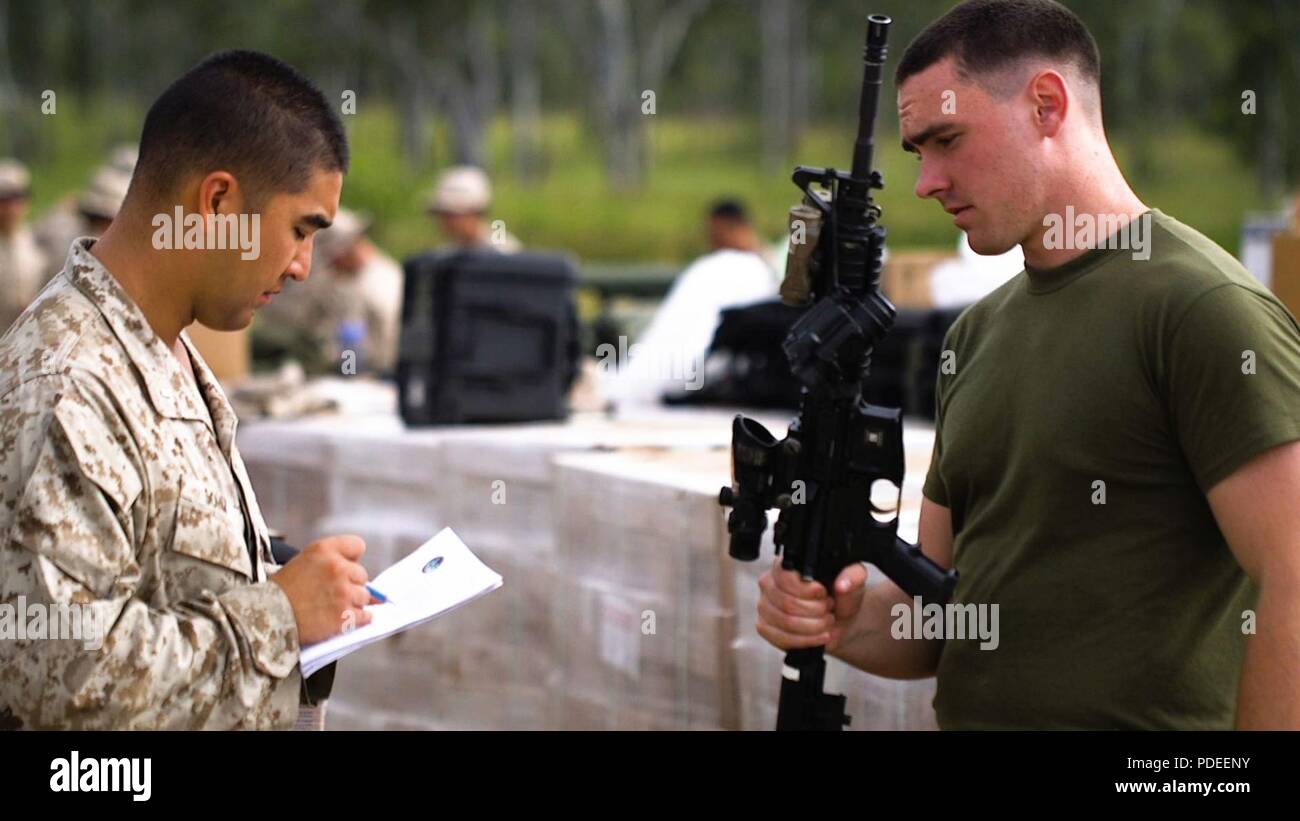1st Lieutenant Ryan Sohm, Weapons Platoon Commander checks the rifle serial number of LCpl. Francis Hollahan that he will use for Marine Rotational Force Darwin (MRF-D) on Shoal Water Bay Training Area, Australia, May 13, 2018. MRF-D was established by former U.S. President Barack Obama and former Australian Prime Minister Julia Gillard in 2011 to build and strengthen partnerships in the Pacific region. Approximately 1,500 Marines are scheduled to participate in training events around the country. Stock Photo