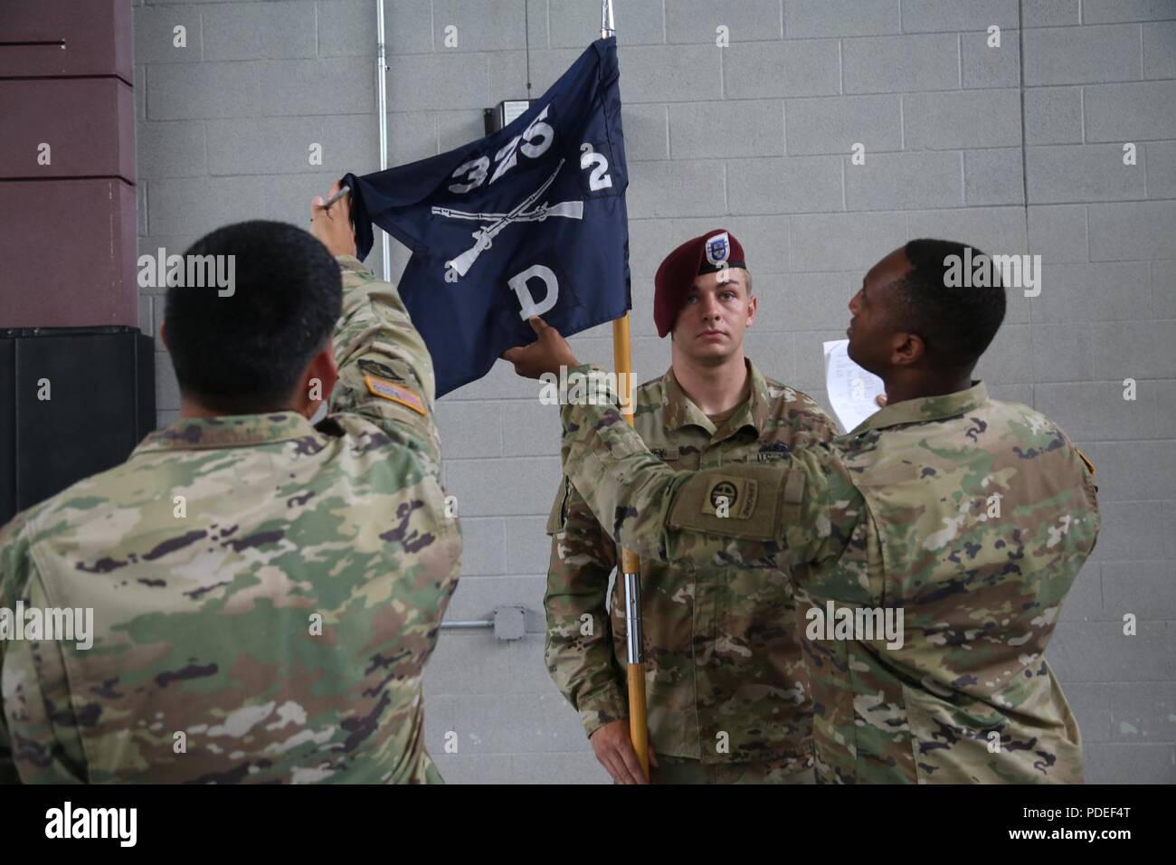 A U.S. Army paratrooper assigned to 325th Airborne Infantry Regiment, 82nd Airborne Divisoin holds the guidon as it is inspected during the All American Week Guidon Competition on Fort Bragg, N.C., May 17, 2018. The guidon bearer serves as the rallying point and representation of each unit and its command element. Stock Photo