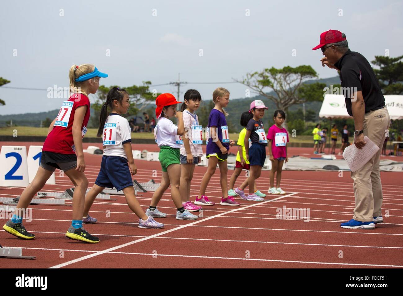 ONNA VILLAGE, OKINAWA, Japan – Children line up to start the 100-meter dash May 19 at the Akama Sports Complex in Onna Village, Okinawa, Japan. The track meet consisted of the 100-m dash, a 100-m relay, long jump, and a vortex football throw. To keep the competition fair, the children were split into grade levels and competed among themselves. Stock Photo