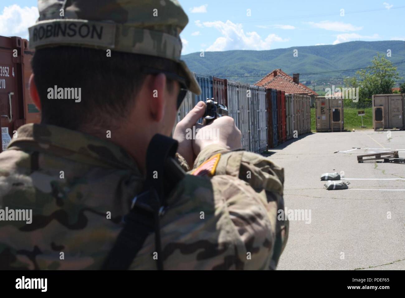 Staff Sgt. Leonard Robinson demonstrates proper hand placement and  sight picture with the M9 pistol during reflexive fire and target acquisition training May 17 at Camp Marechal De Lattre De Tassingny, Kosovo. Stock Photo
