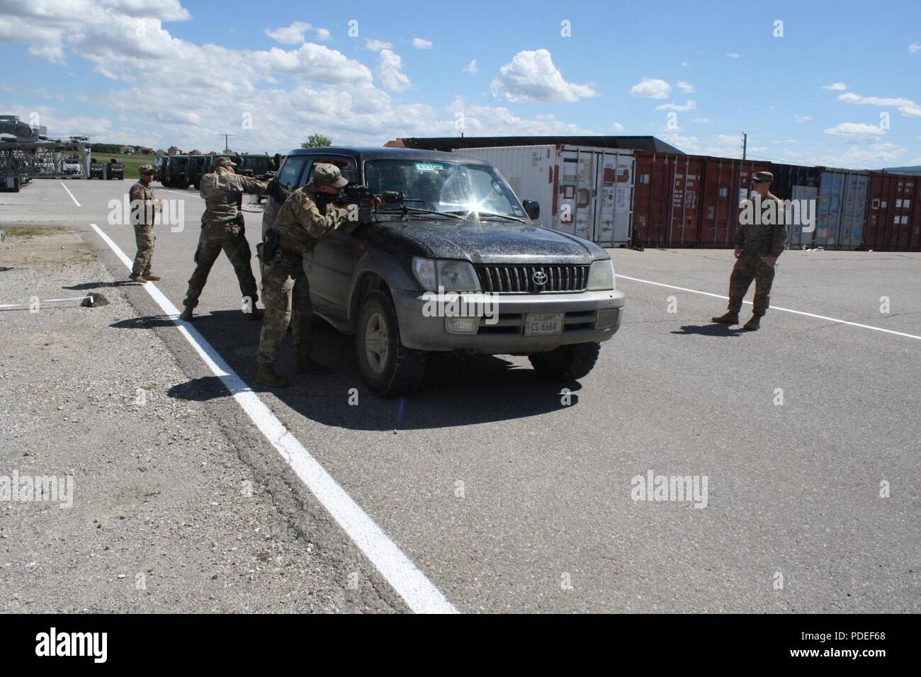 Sgt. Deion Horton and Cpl. Jacob Mathes receive contact and exit the vehicle with  M4 carbines to engage the enemy during  reflexive fire and target acquisition training May 17 at Camp Marechal De Lattre De Tassingny, Kosovo. Stock Photo