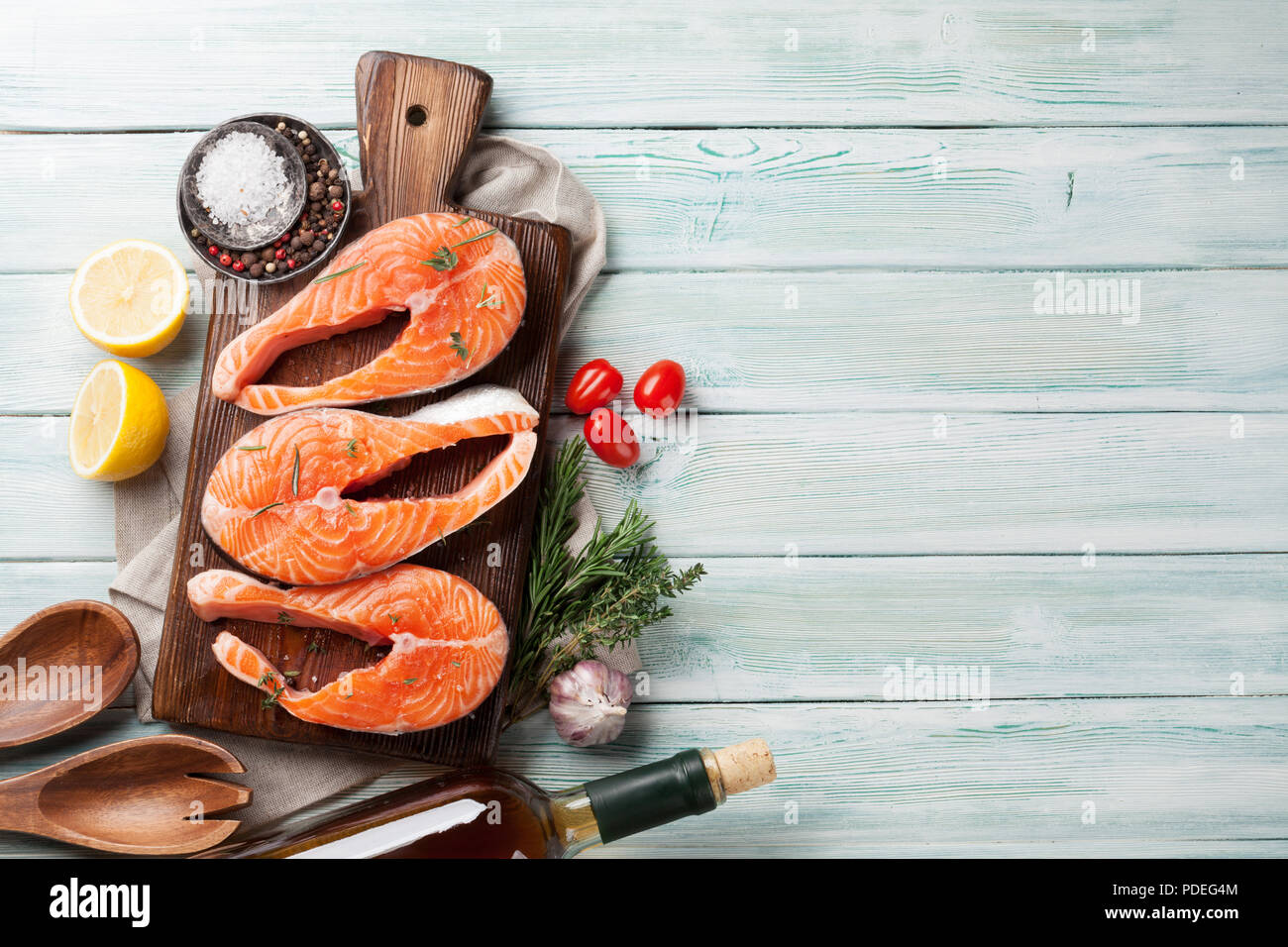 Raw salmon fish steaks with spices cooking on cutting board. Top view ...