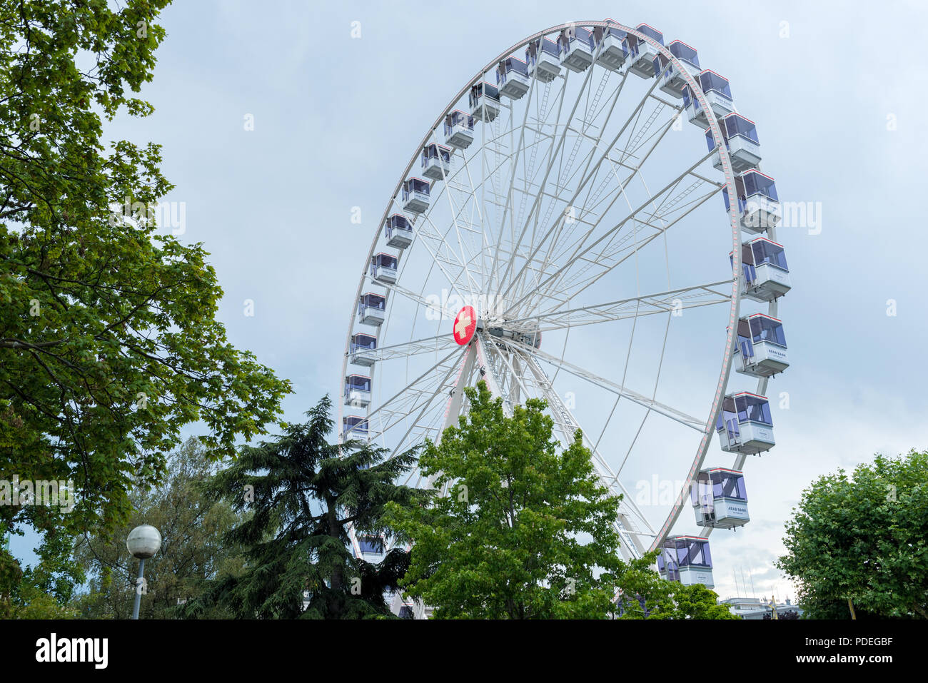 Large ferris wheel in Geneva, Switzerland on the banks of Lac Leman.  Adverts for banks visible on carraiges Stock Photo