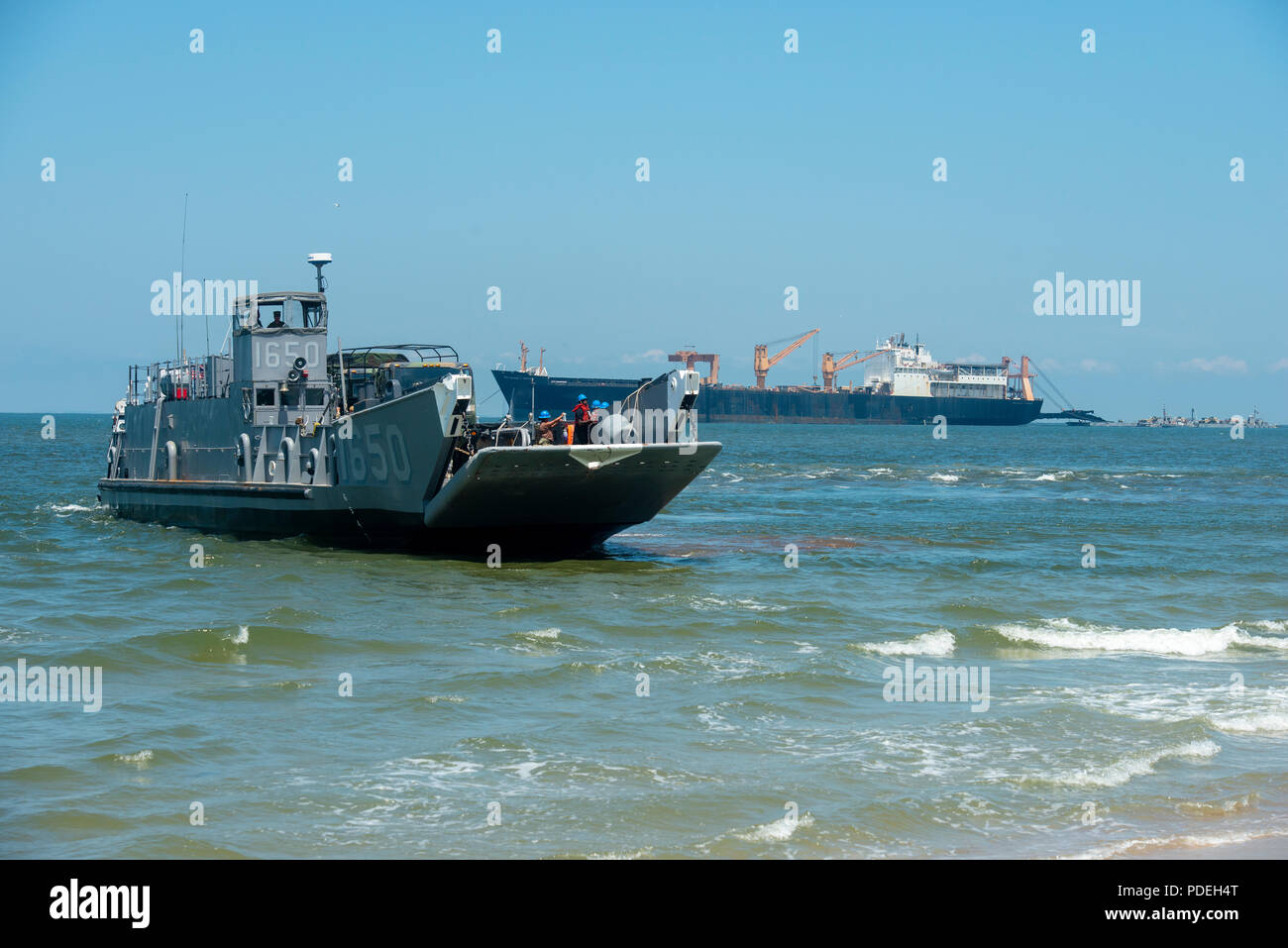 VIRGINIA BEACH, Va. (July 26, 2018) An Assault Craft Unit (ACU) 2 Landing Craft Utility (LCU) 1600 begins lowering the bow ramp in order to offload U.S. Army vehicles after stabbing Utah Beach during the Trident Sun 18 exercise onboard Joint Expeditionary Base Little Creek – Fort Story. Trident Sun 18 is a maritime prepositioning force (MPF) operation intended to provide training to reserve component personnel with regards to the in stream offload of military vehicles and equipment. (U.S. Navy photo by Mass Communication Specialist 2nd Class Kenneth Gardner) Stock Photo