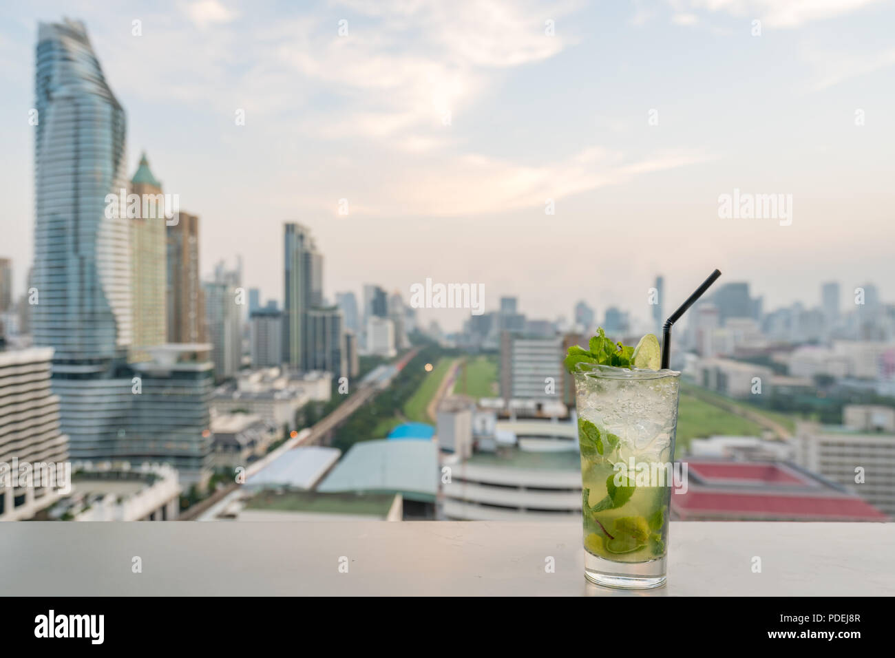 Mojito cocktail on table in rooftop bar with Bangkok city view point in