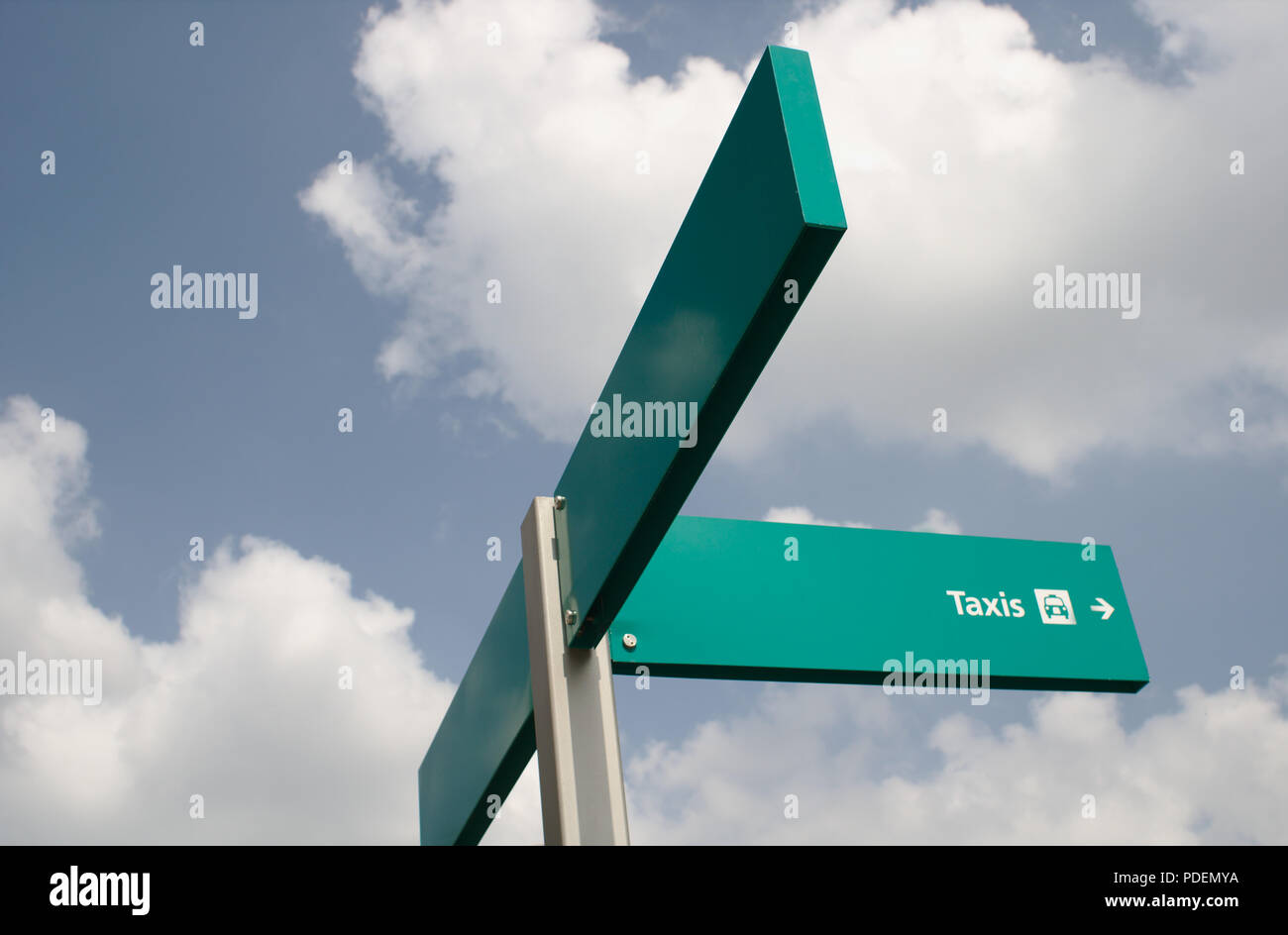 A taxi sign against a blue sky with clouds. Space to the left for text. Stock Photo