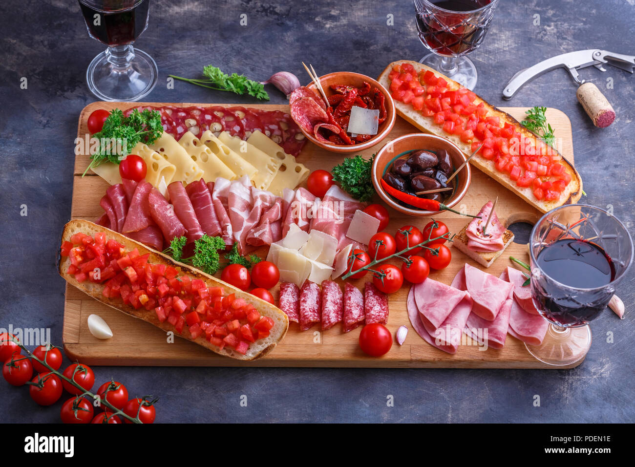 Cutting board of Assorted Cured Meats, Cheese, bread and wine Stock Photo