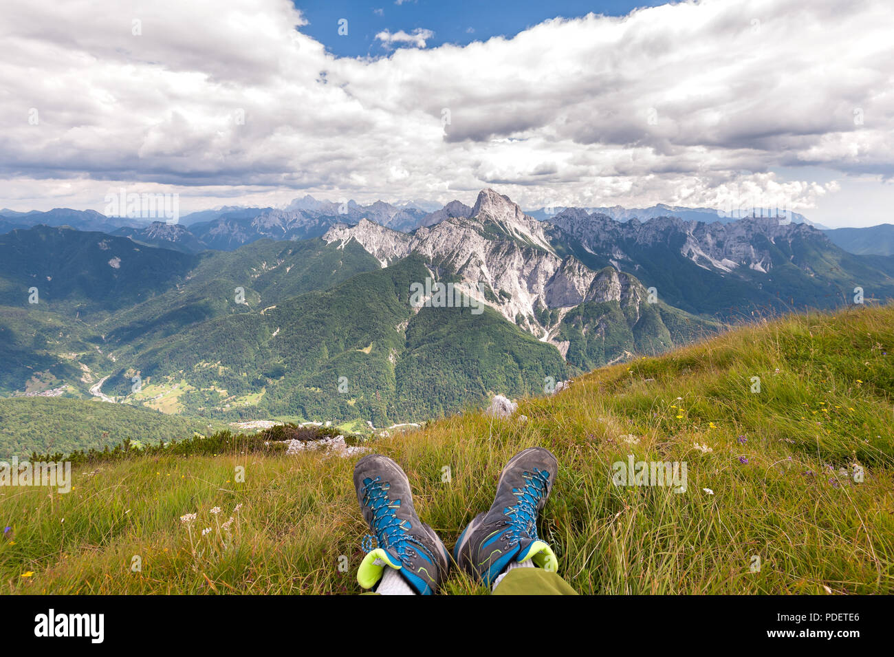 Hiker boots. Rambler having fun and enjoying wonderful breathtaking mountain view. Freedom concept. Italian Alps. Friuli Venezia Giulia. Concept of ad Stock Photo