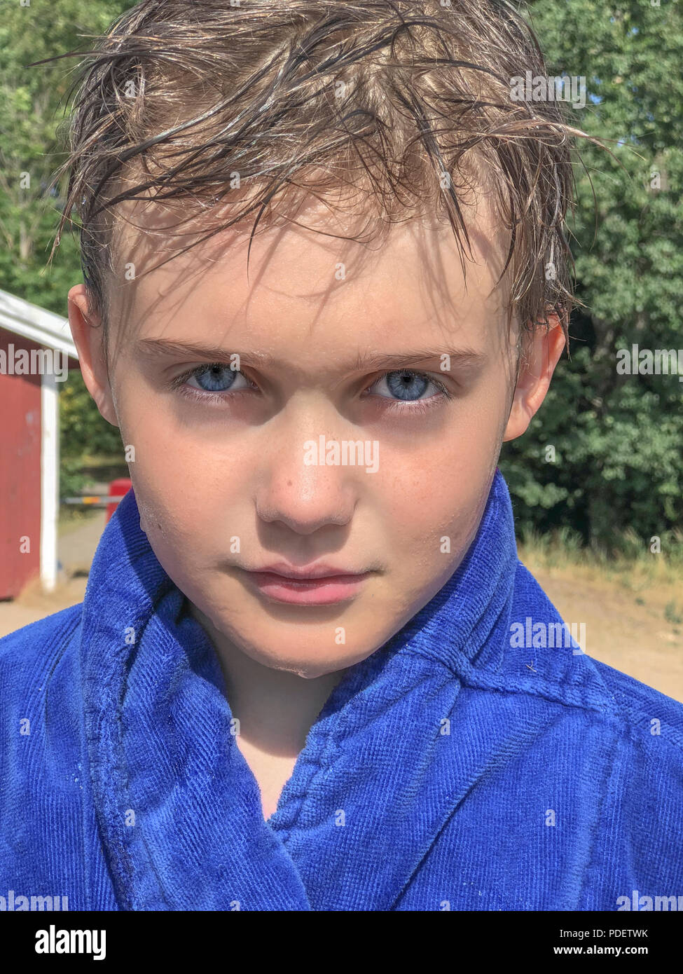 Handsome young caucasian boy with beautiful blue eyes looking at camera with neutral determined confident expression Stock Photo