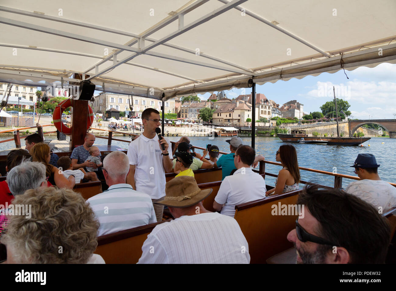 Bergerac tourism - tourists on a boat trip on a traditional Gabarre, Dordogne River at Bergerac, Dordogne France Europe Stock Photo