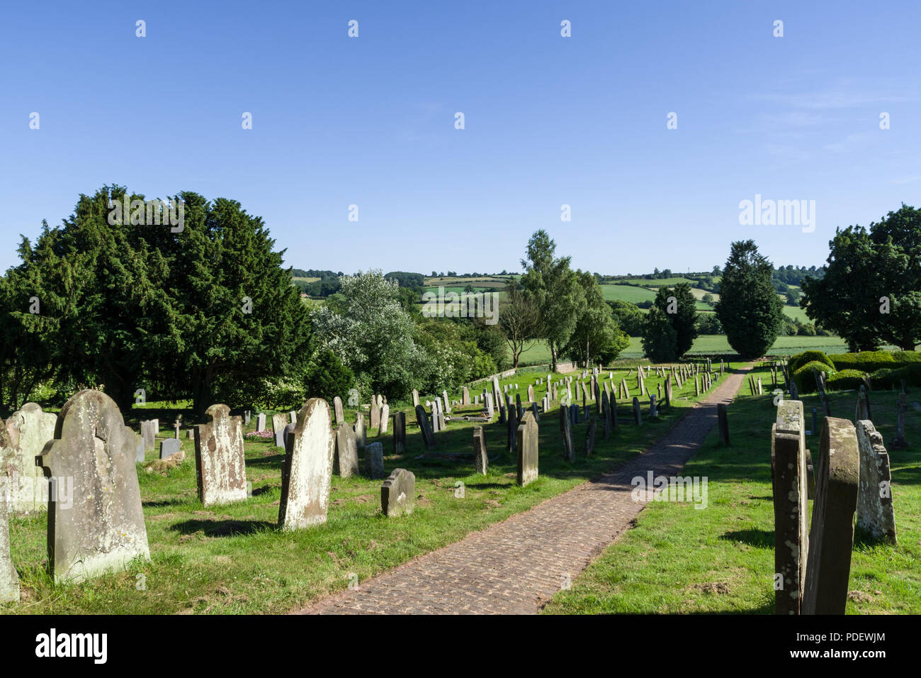 a view across the graveyard to the countryside beyond, from the church of St Michael in the village of Coxwold, North Yorkshire, UK Stock Photo