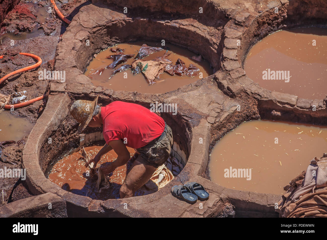 Fes, Morocco - May 11, 2013: Workers handling hides at a tannery in Fes, Morocco Stock Photo