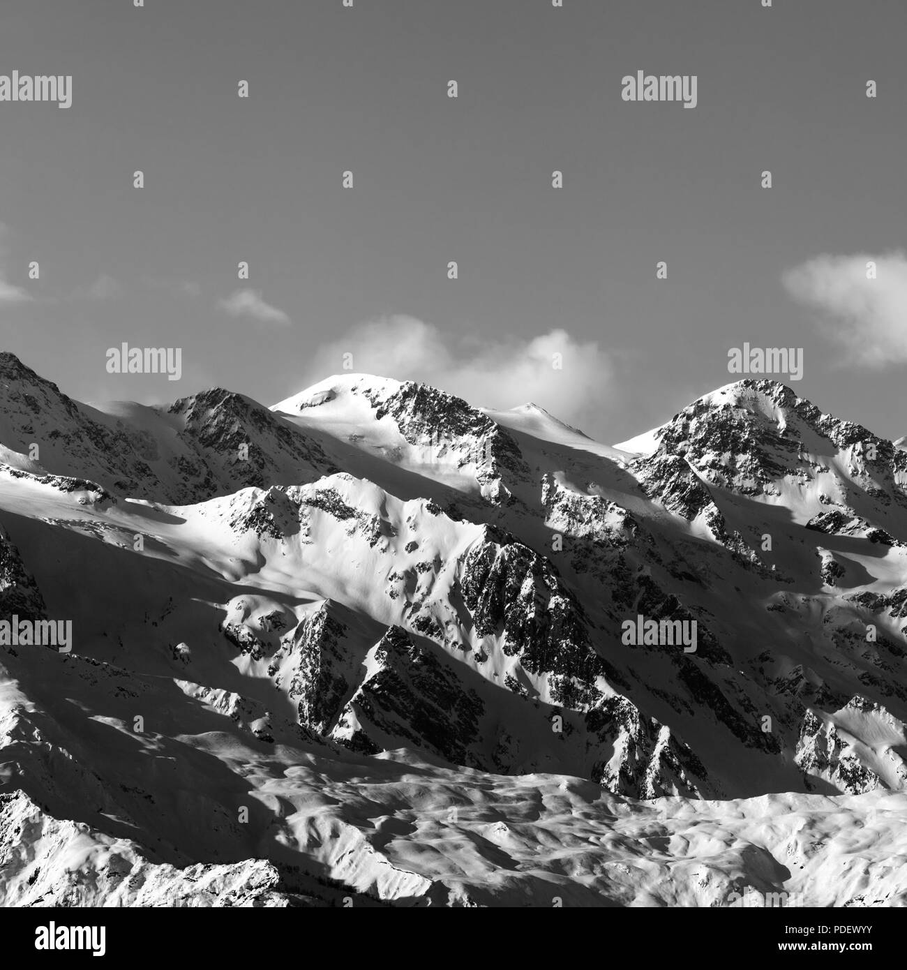 Black and white snowy winter mountains at sunny evening. Caucasus Mountains. Georgia, region Svaneti. Square image. Stock Photo