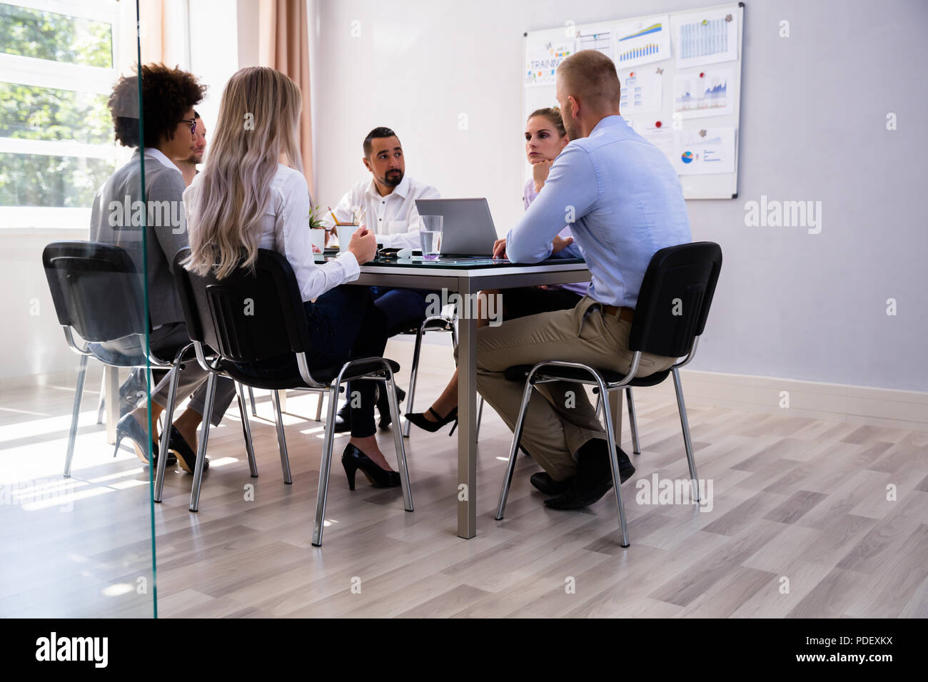 Group Of Businesspeople Sitting In Office During Business Meeting Stock ...