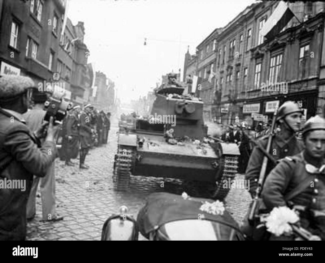 380 Wojska pancerne podczas defilady widoczny czołg lekki 7 TP. Z lewej mężczyzna z ręczną kamerą filmową Stock Photo
