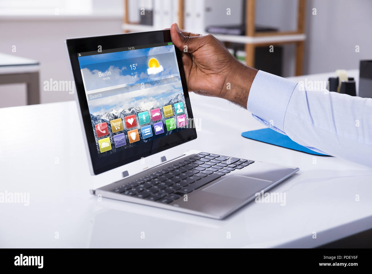Close-up Of A Businessman Attaching Digital Tablet To Convertible Laptop Stock Photo