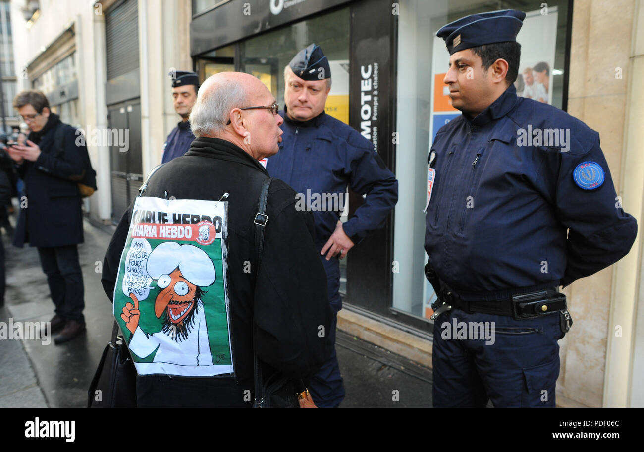 January 08, 2015 - Paris, France:  A man pays tribute to Charlie Hebdo by wearing one of the satirical magazine's controversial issue on his back  Des gens se recueillent pres d'un memorial improvise au lendemain de l'attaque meurtriere contre Charlie Hebdo. *** FRANCE OUT / NO SALES TO FRENCH MEDIA *** Stock Photo
