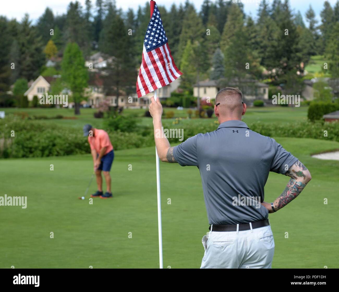 Sgt. Joseph Erlach, from the 42nd Military Police Brigade on Joint Base Lewis-McChord, tends the ninth hole flagstick during the Muckleshoot Casino Washington Open Pro-Am May 19 at the Meridian Valley Country Club in Kent, Washington. The event took place over Armed Forces Weekend. U.S. Army Stock Photo