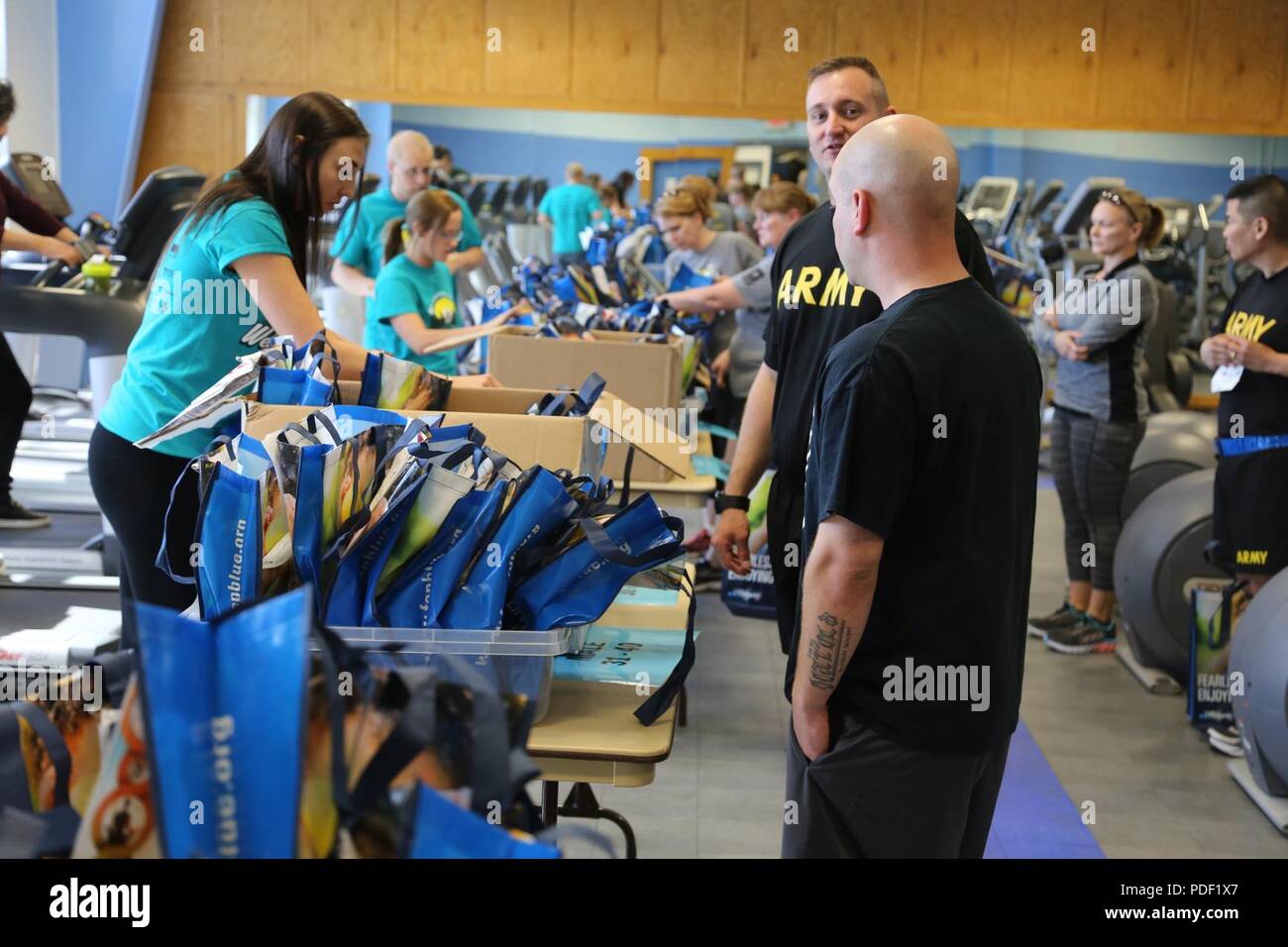 Prospective runners pick up their packets prior to the start of the Wellness Fair 5k Run/2-mile Walk on May 16, 2018, at Rumpel Fitness Center at Fort McCoy, Wis. The race was part of the overall Fort McCoy Wellness Fair. More than 500 people attended fair where they attended the race or visited dozens of information displays featuring products and services from local businesses and post agencies. The Directorate of Family and Morale, Welfare, and Recreation organized the event during which the American Red Cross held a blood drive; health screenings were offered; and 49 door prizes were given Stock Photo