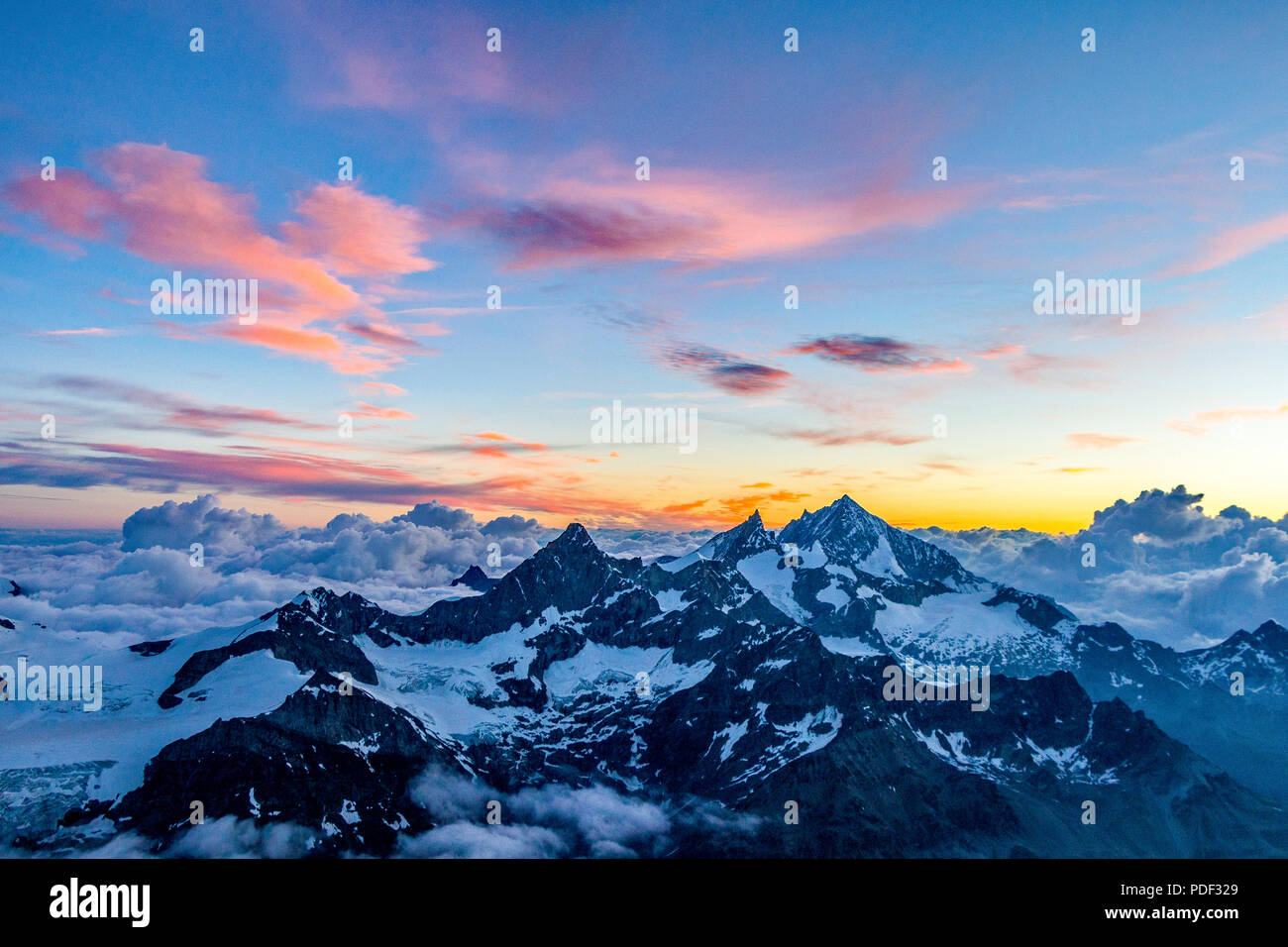 A dramatic view of mountain peaks above the clouds at sunrise I the ...