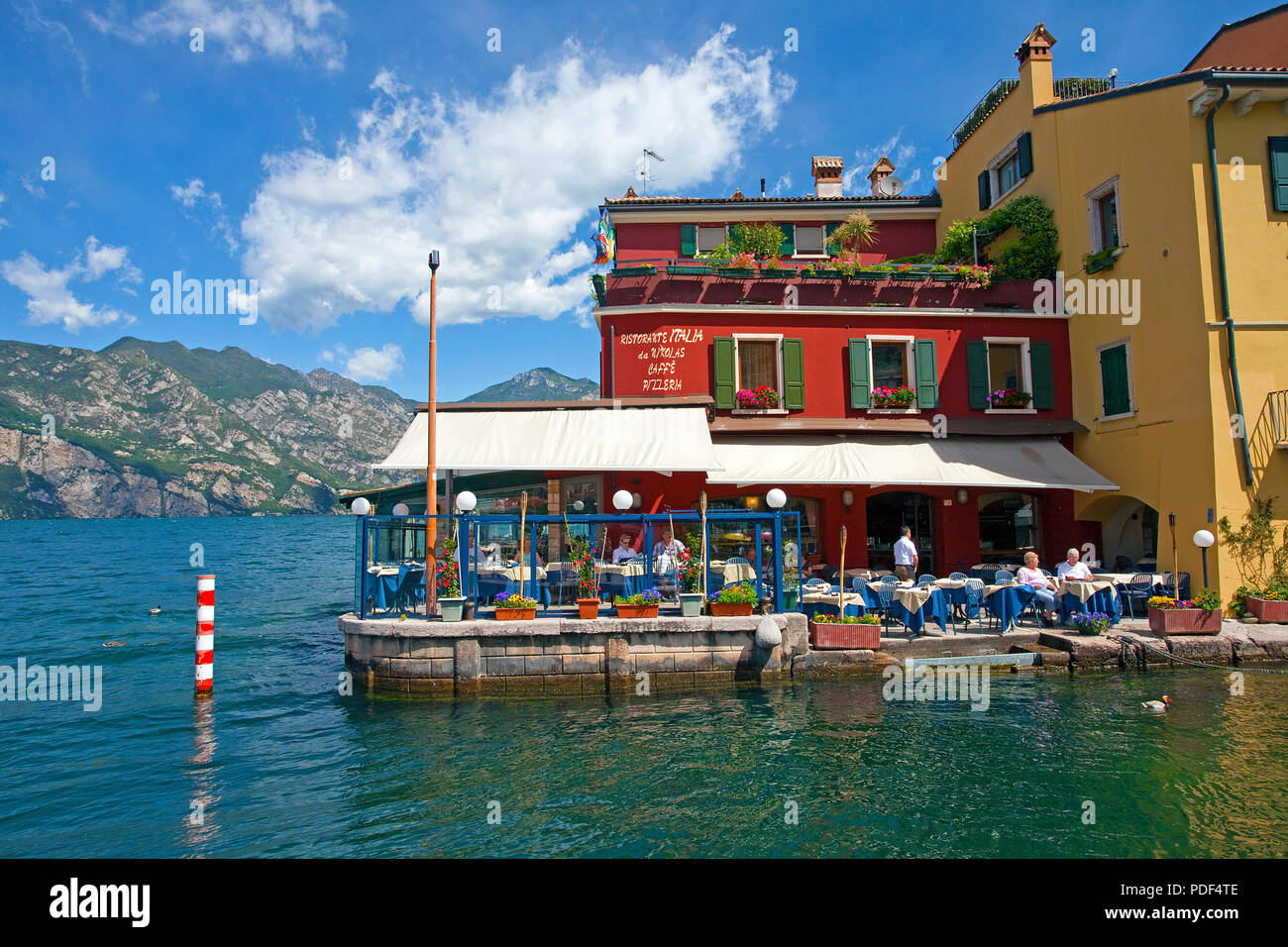 Idyllic restaurant at lakeside, harbour of Malcesine, province Verona, Lake Garda, Lombardy, Italy Stock Photo