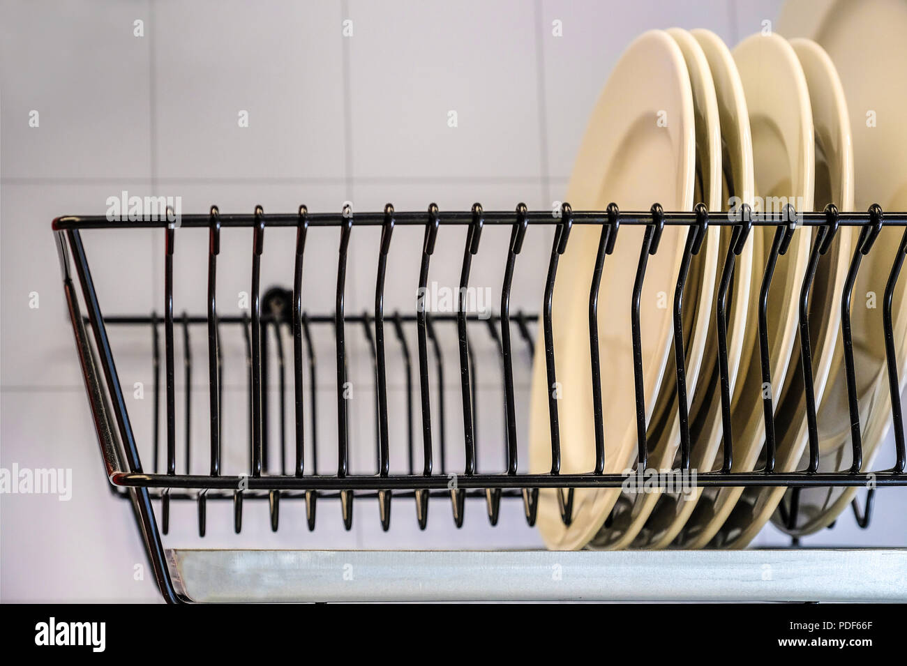 https://c8.alamy.com/comp/PDF66F/white-dishes-drying-on-metal-dish-rack-dish-drying-rack-the-dryer-is-fixed-horizontally-on-the-wall-PDF66F.jpg
